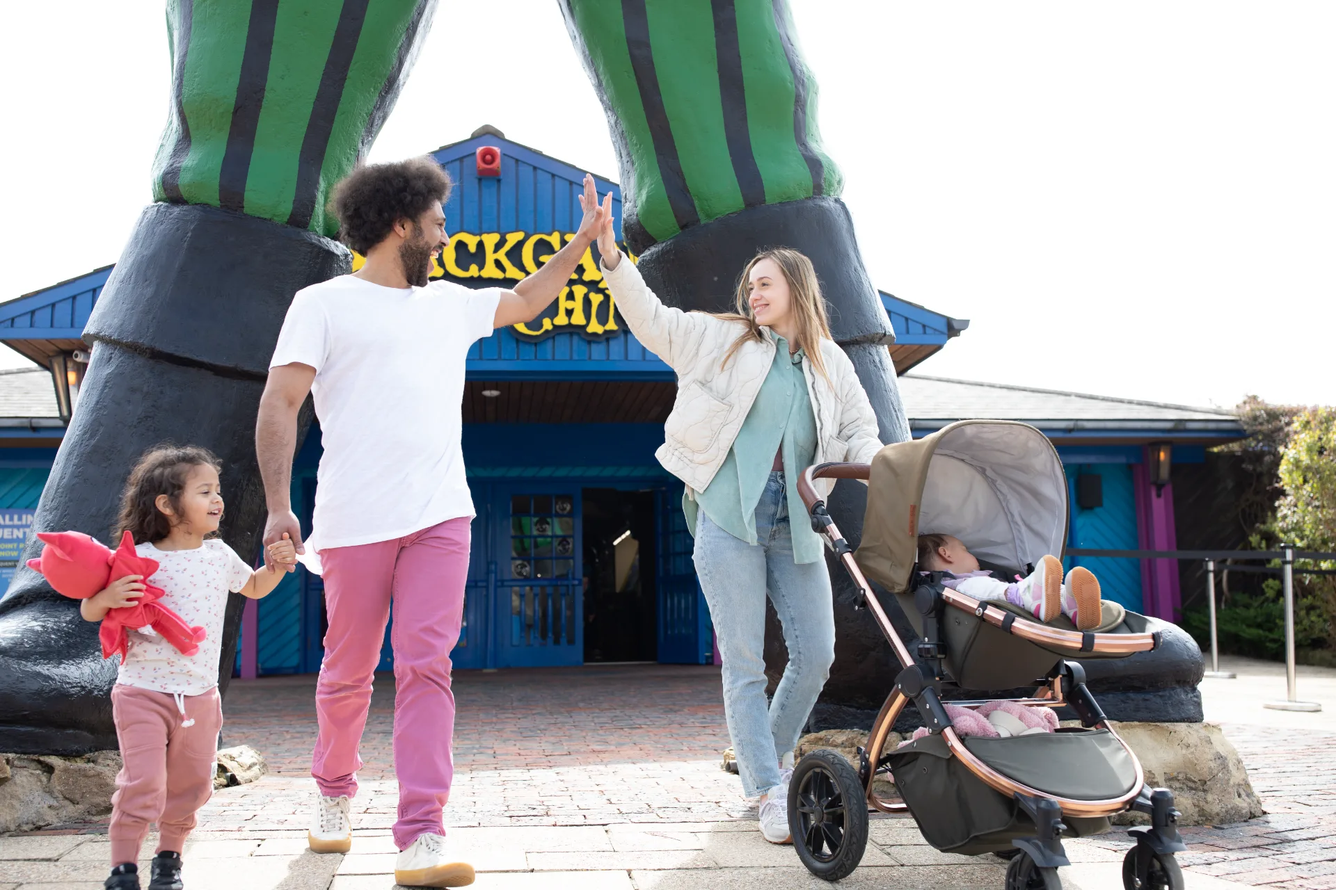 family of four in front of the blackgang chine theme park sign